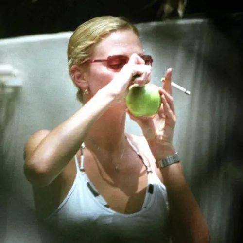 Charlize Theron smoking a cigarette…and an apple 😉