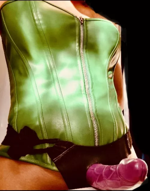 Leather corsets and strapons go together almost as well as purple and green! Now let’s cut to the chase, face down ass up and be a good boy 😈