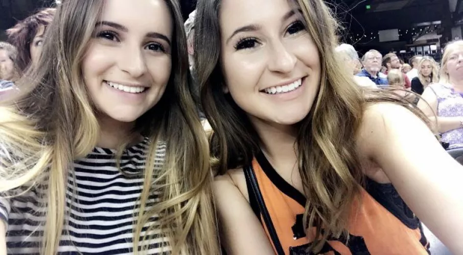 Which sister is putting her mouth to work in the stadium bathroom? [2]