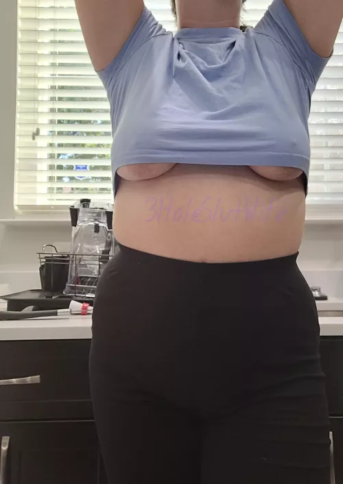 Underboob pops out reaching for the top shelf