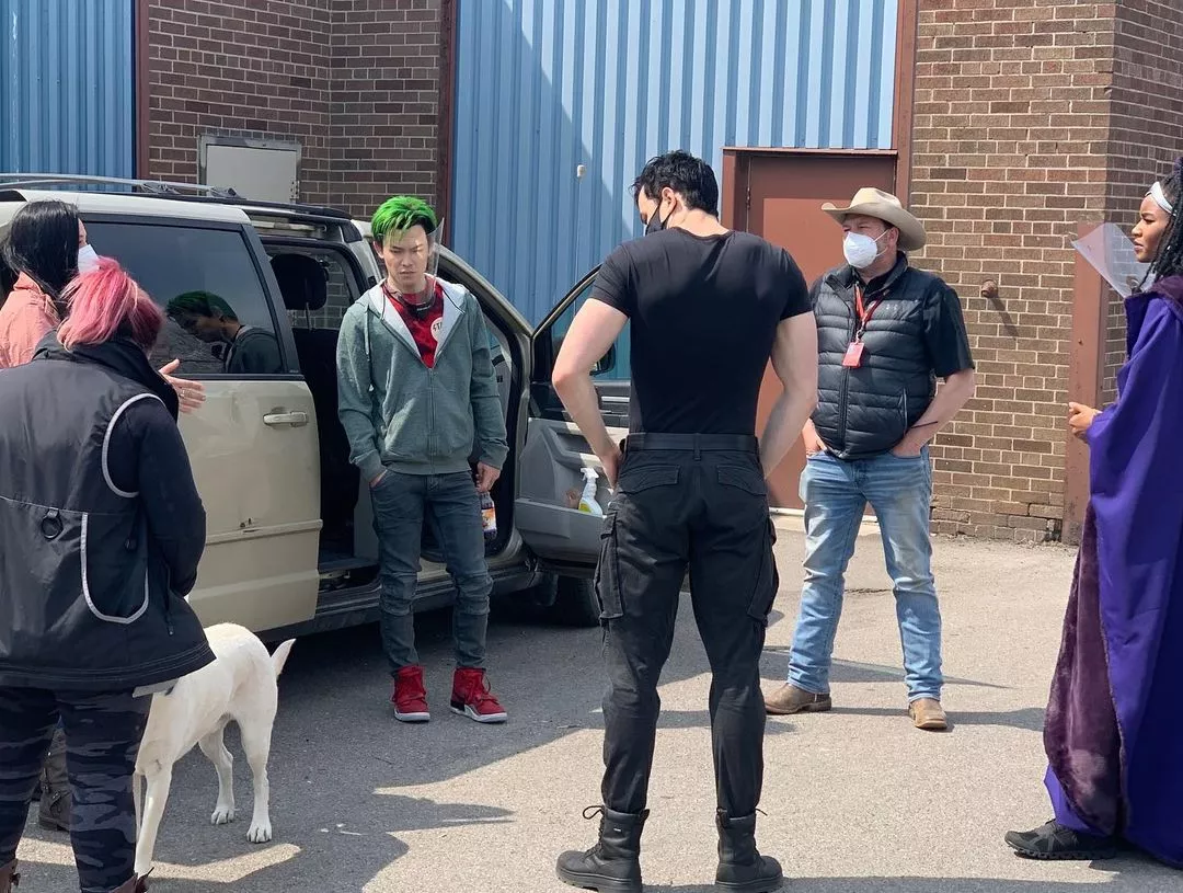 Need Help - Does anyone recognize the boots themselves or what the logo could be on the boots of the man in black with his back to the camera? Trying to find his boots! Thank you for any help you can offer!