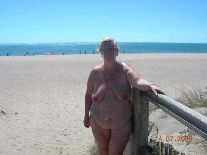 Mature woman at the edge of nude beach. Source unknown
