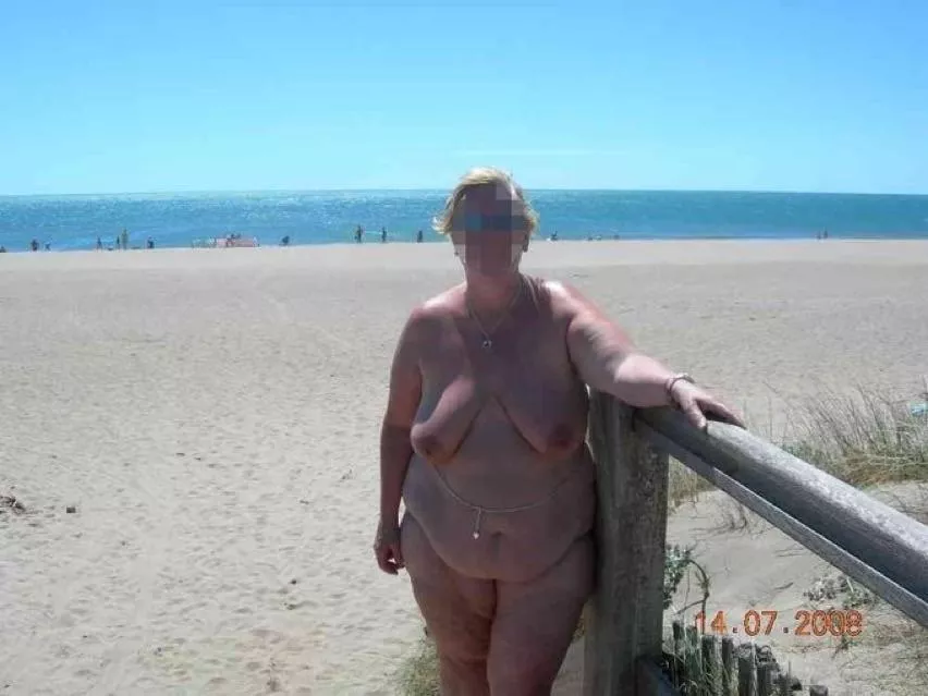 Mature woman at the edge of nude beach. Source unknown