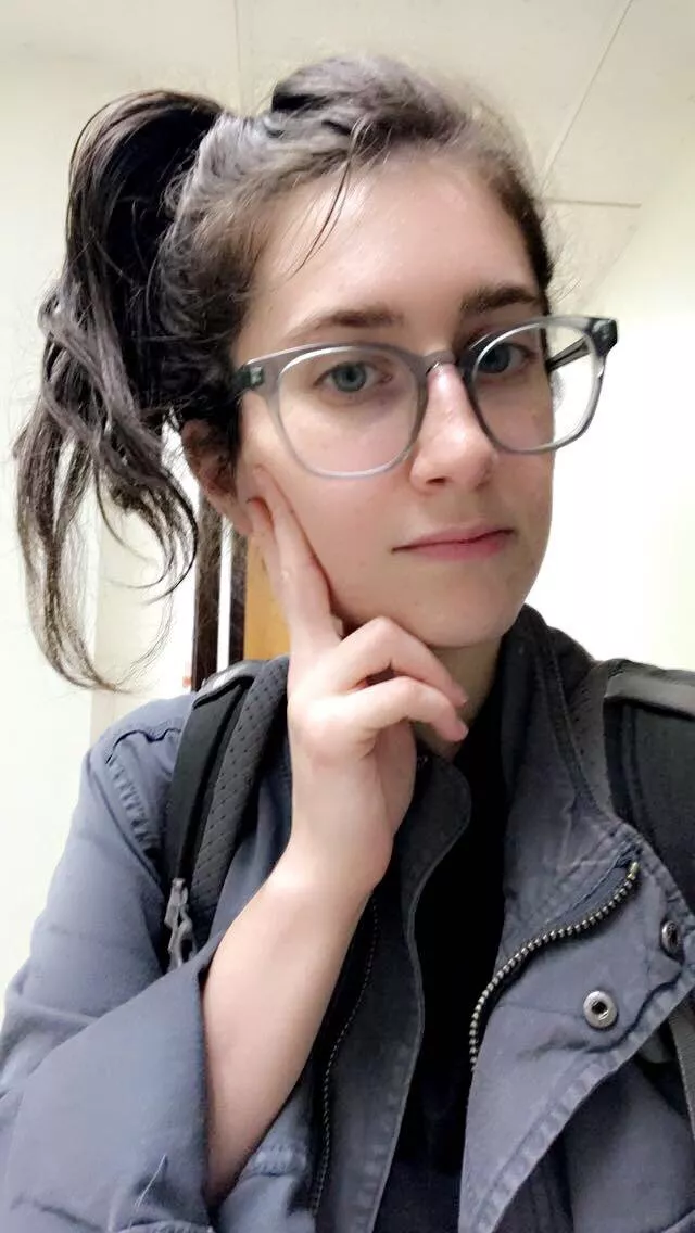 Pensive fully clothed girl with glasses