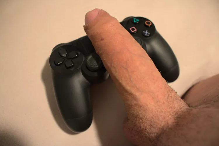 My uncut cock next to a PS4 controller