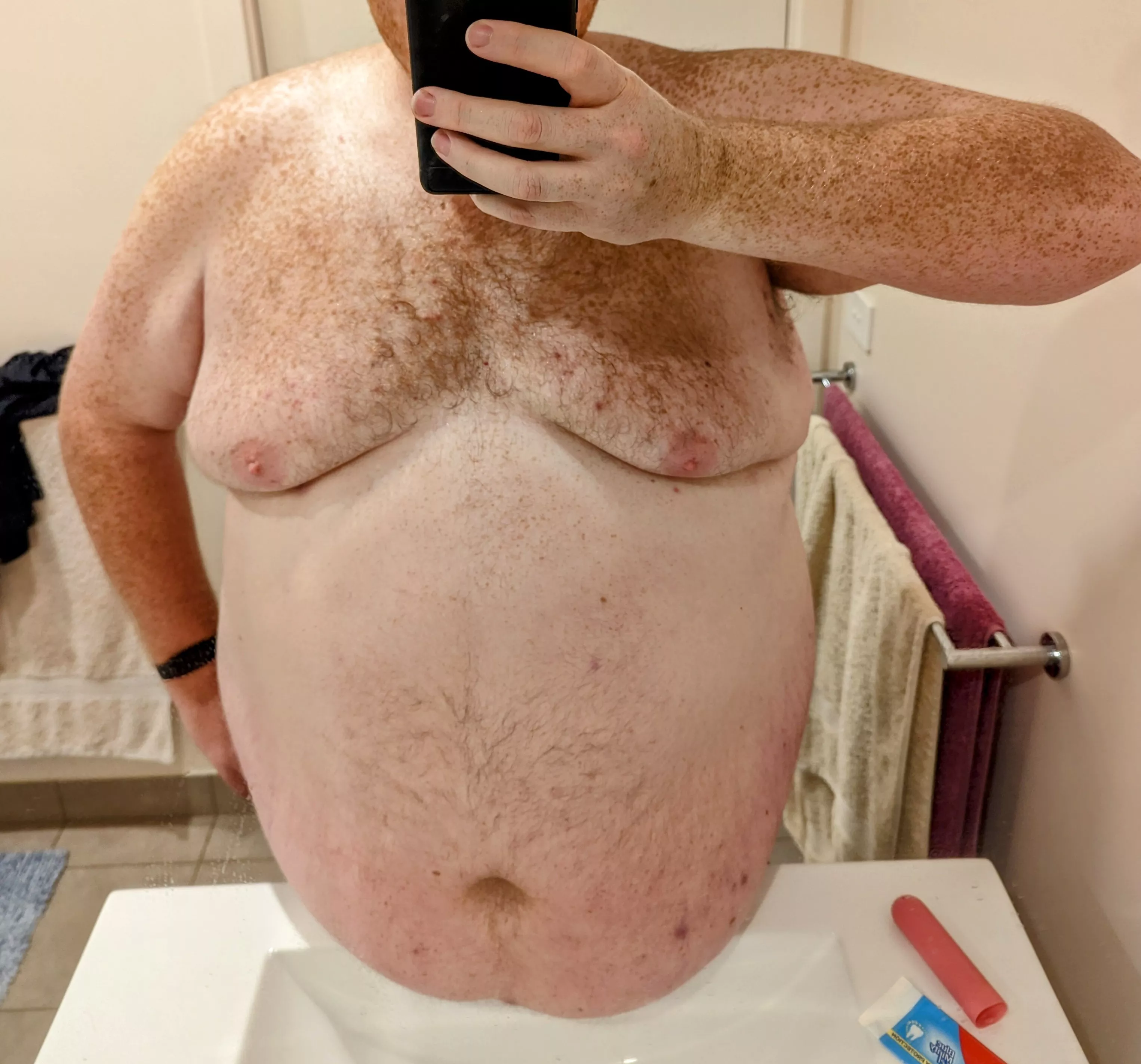 Some belly resting on the bathroom sink