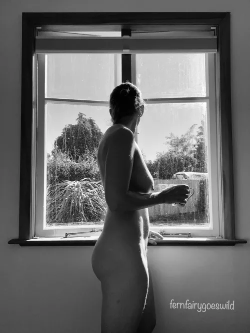 Nudist having coffe by the window