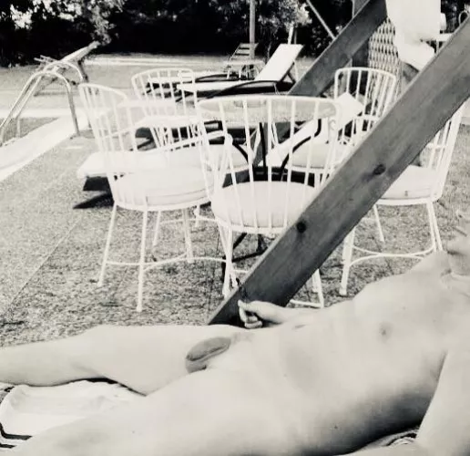 42 M chilling out at the pool in a nudist hotel in Greece .