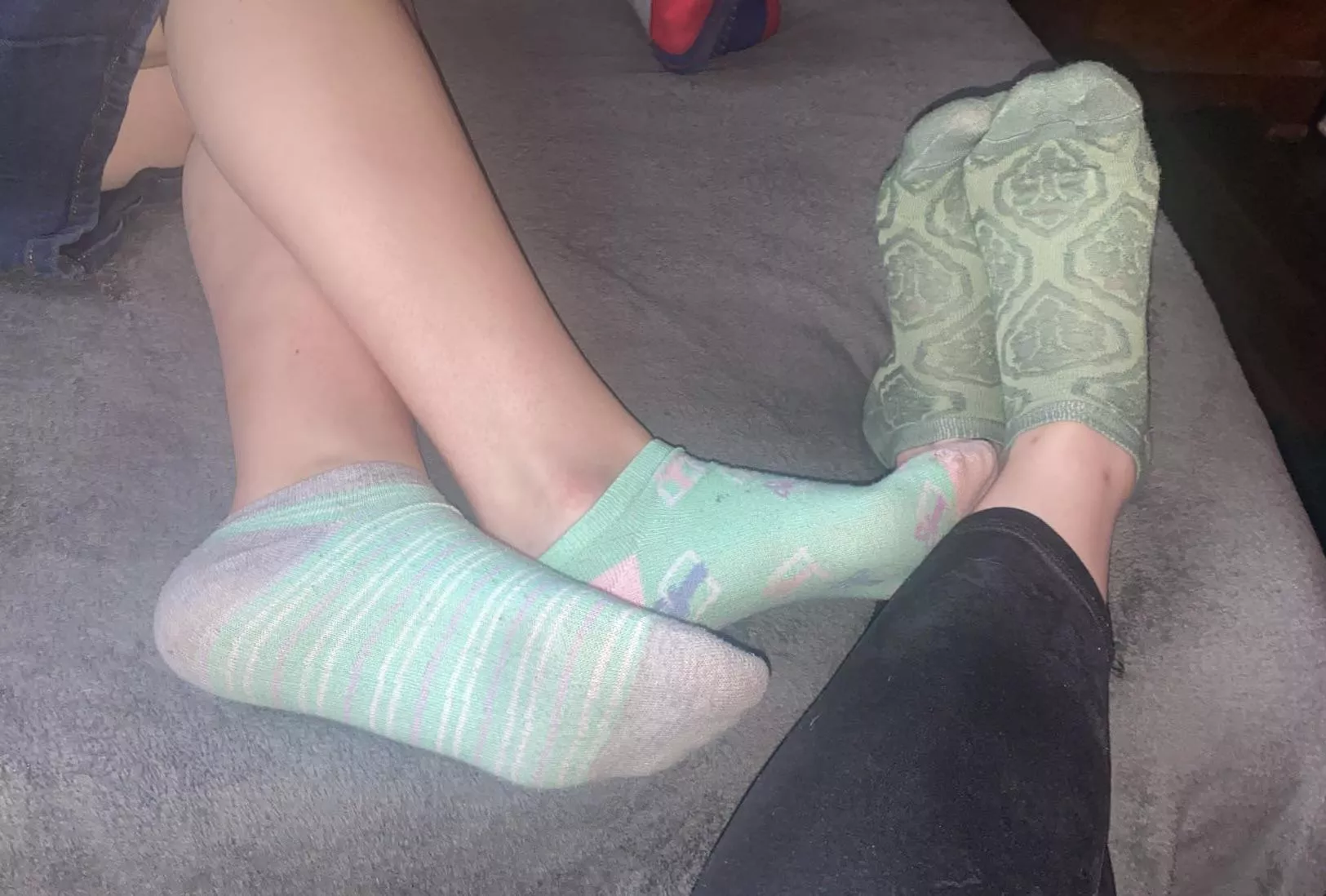 Her slightly sweaty socks resting against my feet..