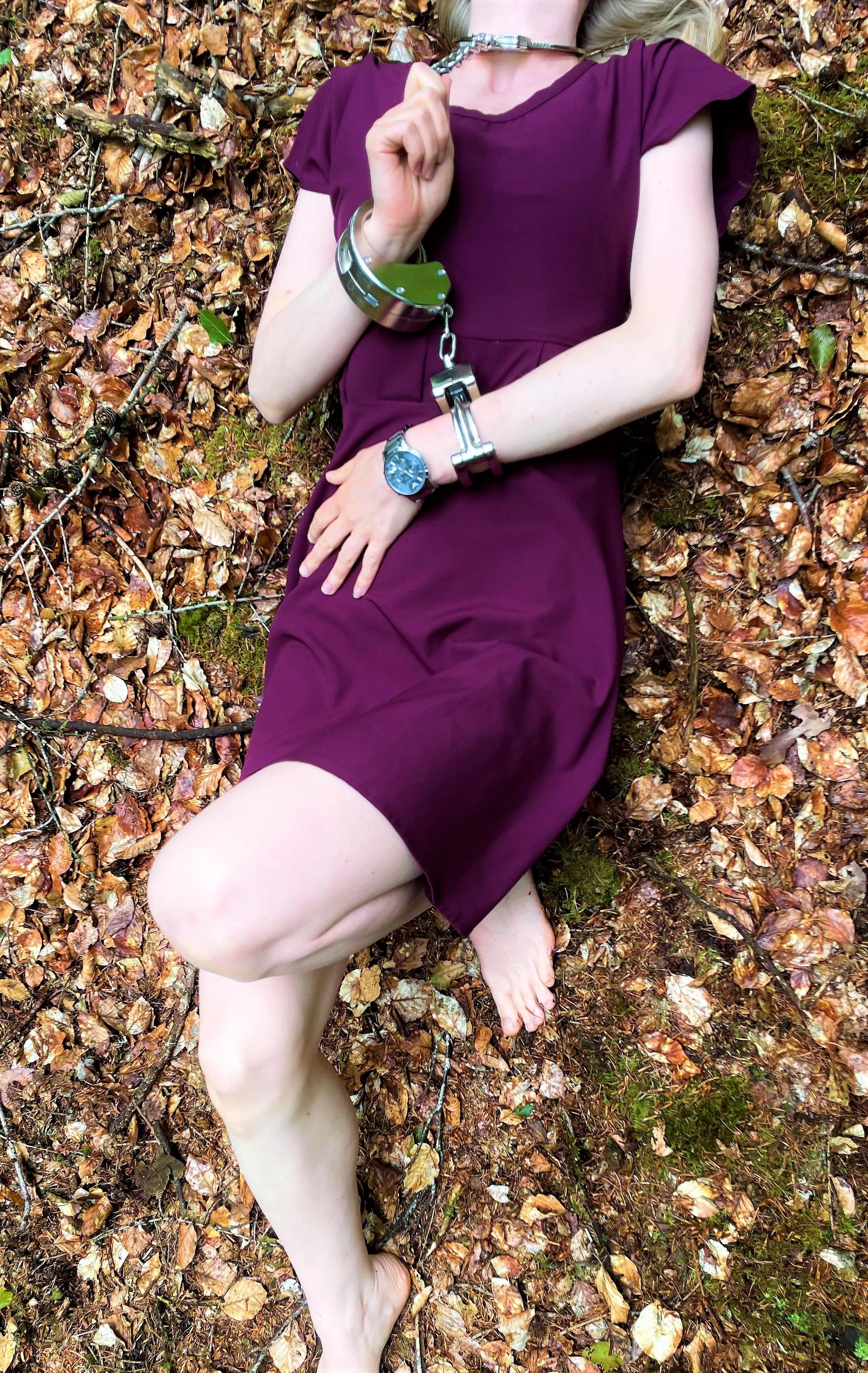 Lying chained on the forest floor (neckcuff, heavy handcuffs)