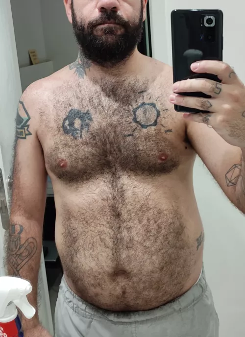 Sweaty hairy man cleaning the mirror