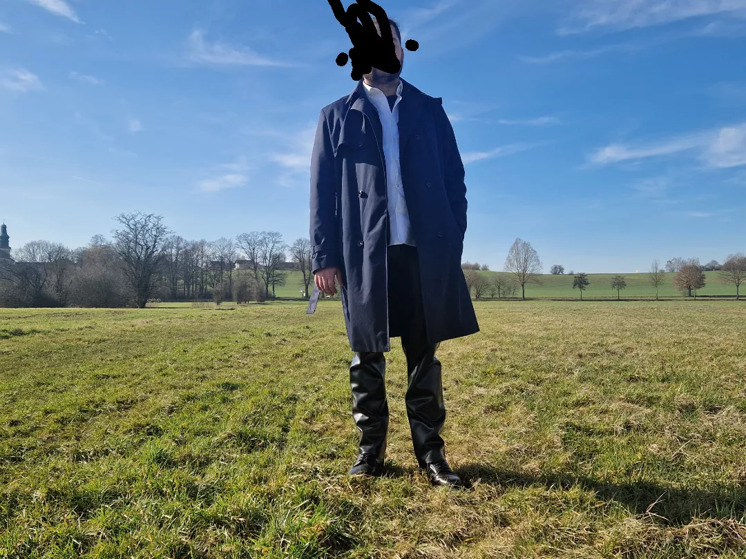 enjoying my latextrousers with my trenchcoat in the sun