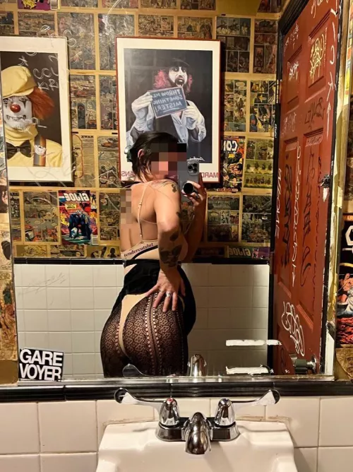 Pulling up my skirt to show off my fishnets in the bar bathroom