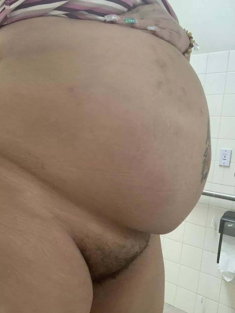 In the work bathroom showing my big belly and bush