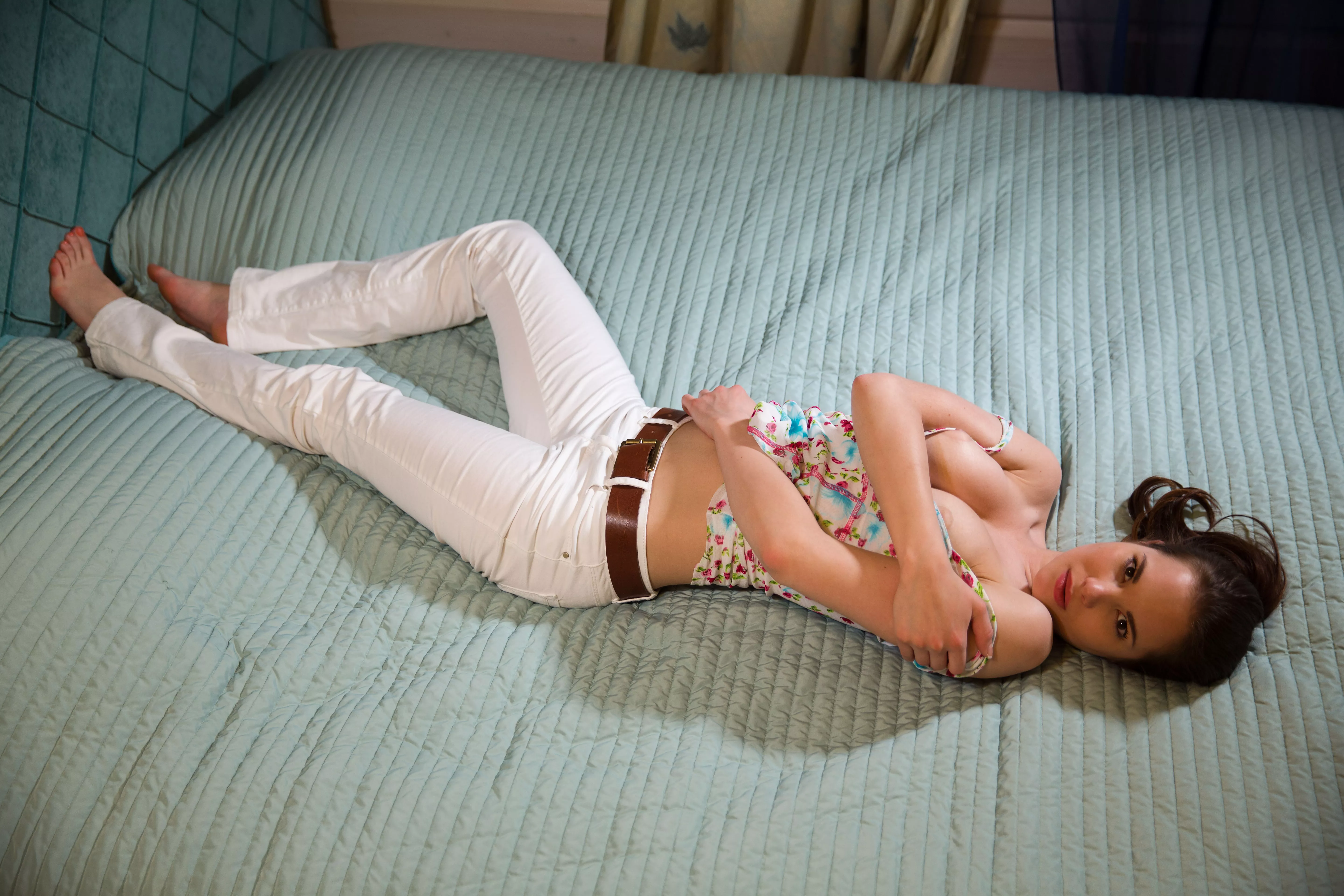 in white jeans on the bed