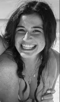 A very beautiful Bikini girl laying down with an ocean behind her...