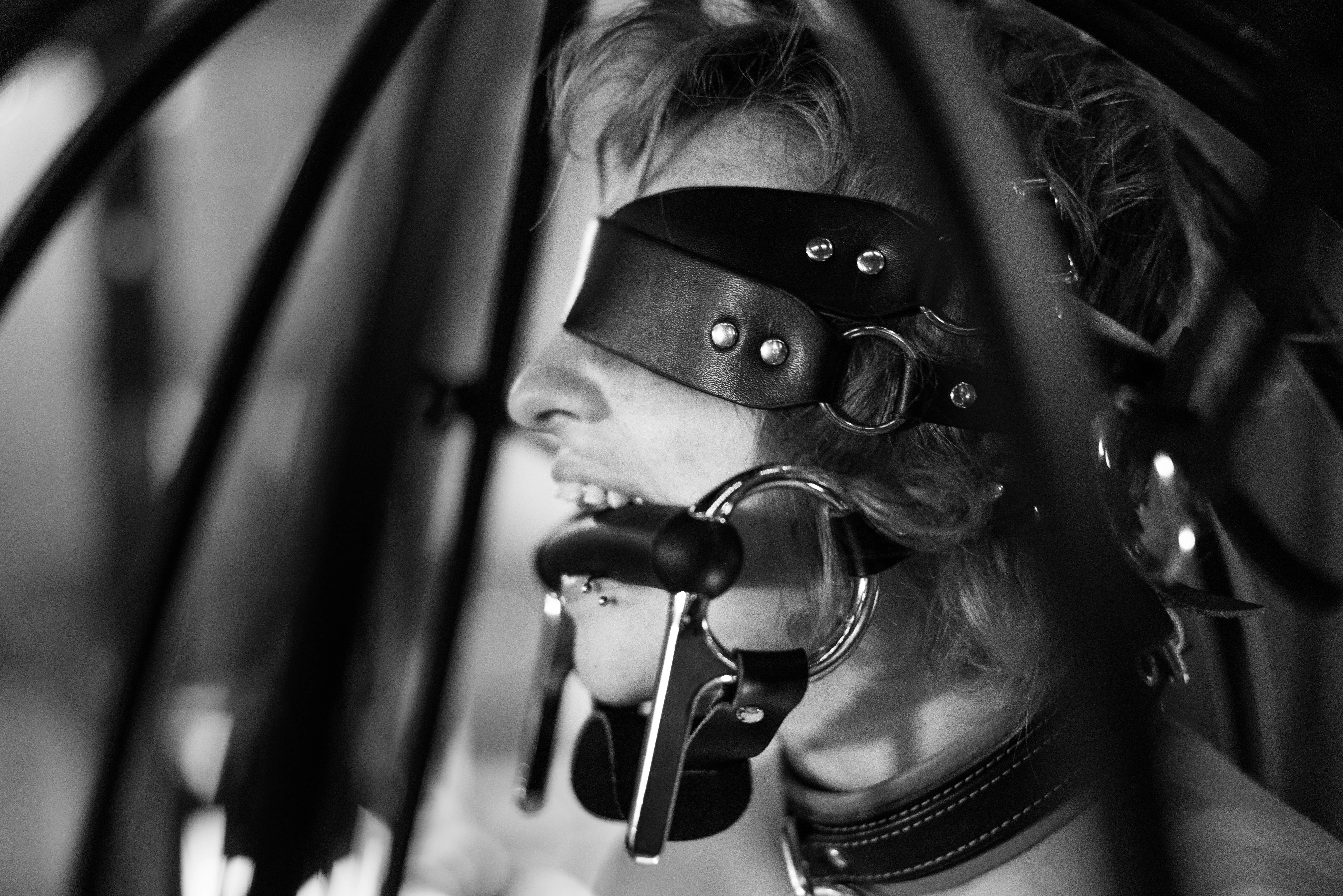 Genesis Fae bit gagged, collared, and blindfolded in a hanging cage, photo by Me