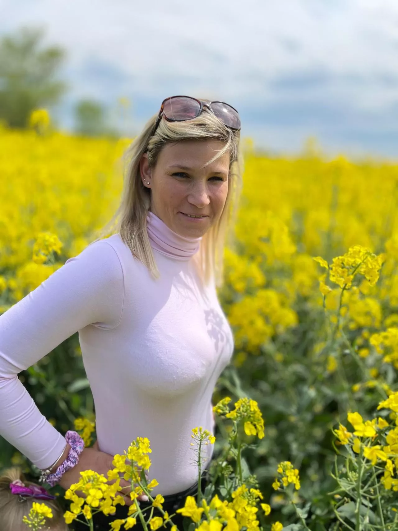 Bra lines beneath a tight pink top in a flowery field
