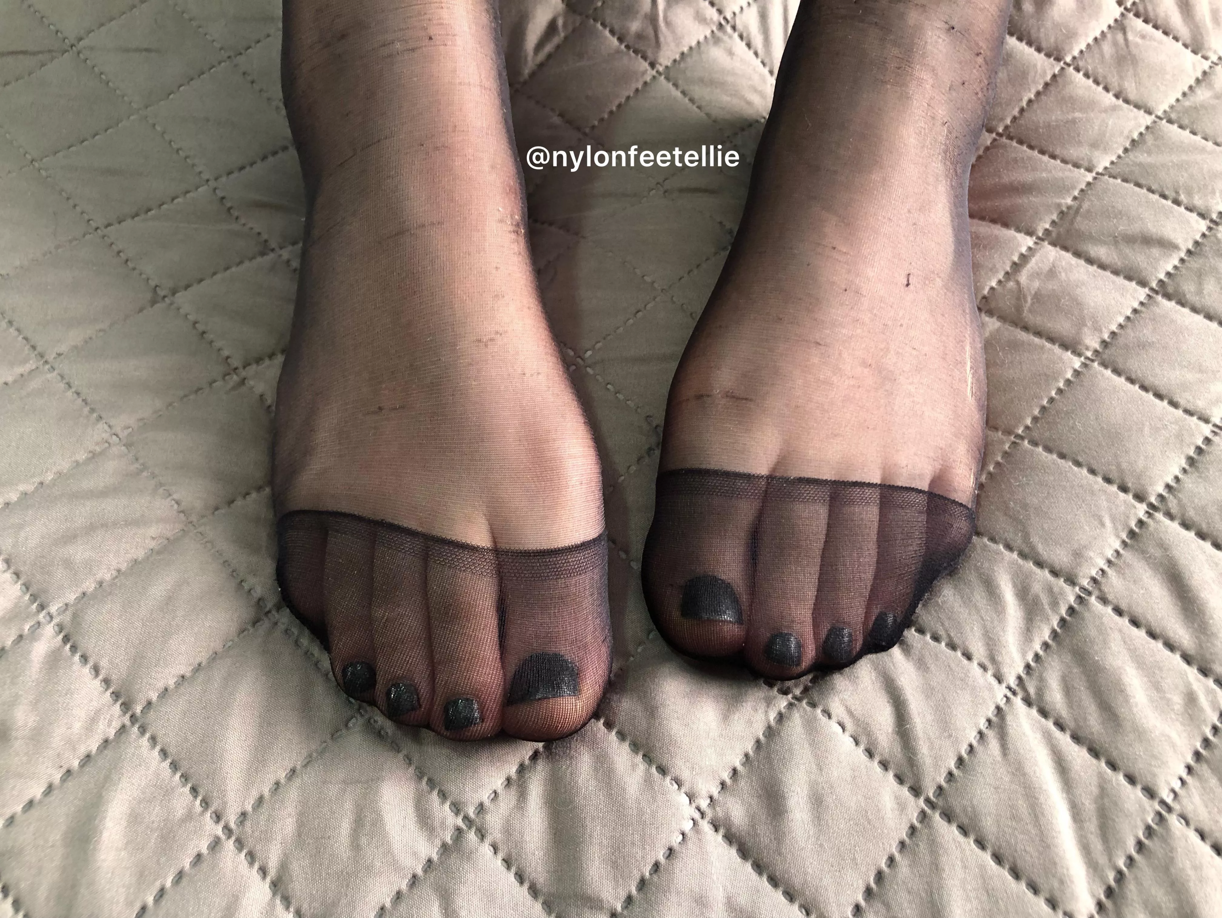 Shiny black nail polish and reinforced toe black pantyhose.