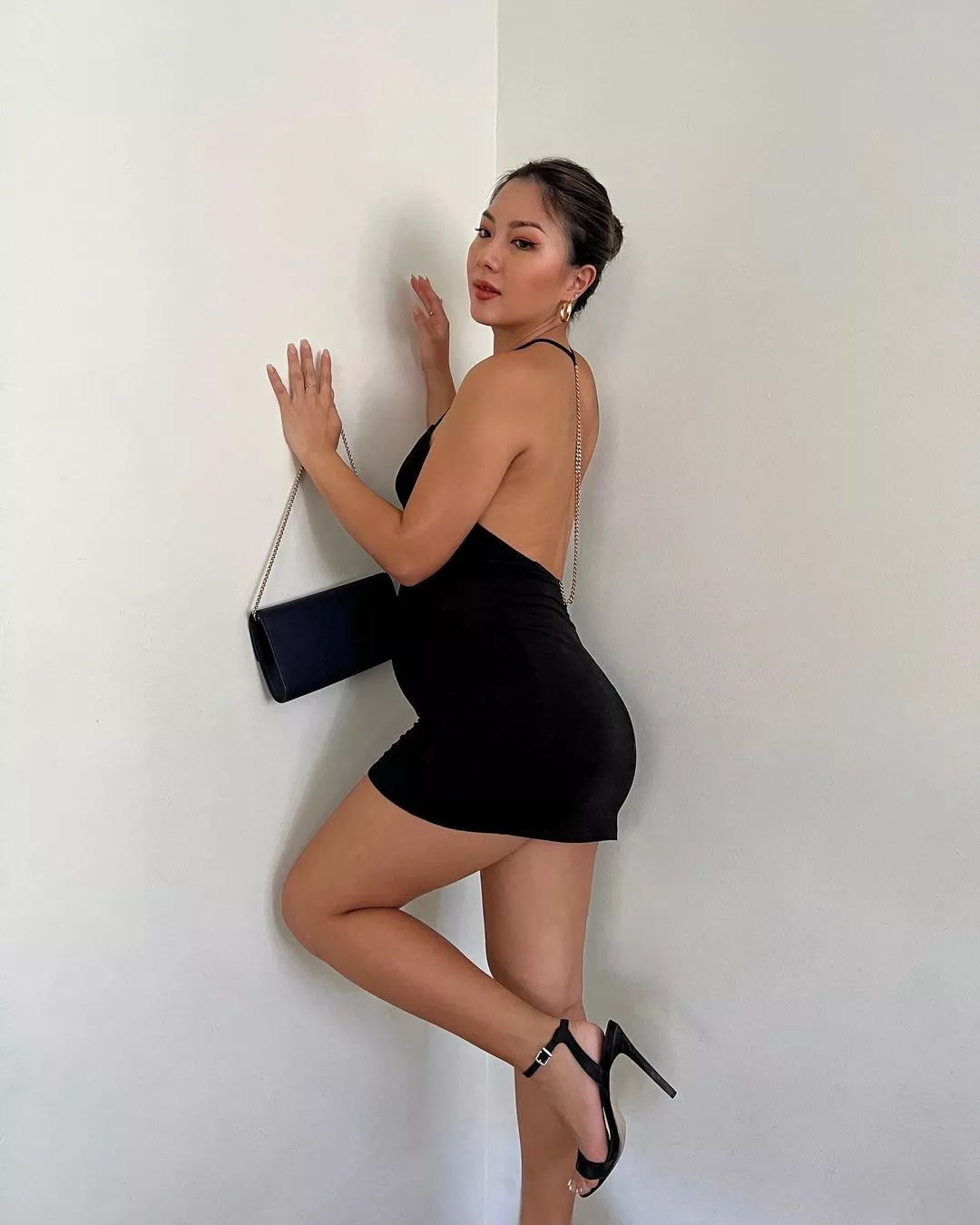 Little elegant black dress on a pregnant body