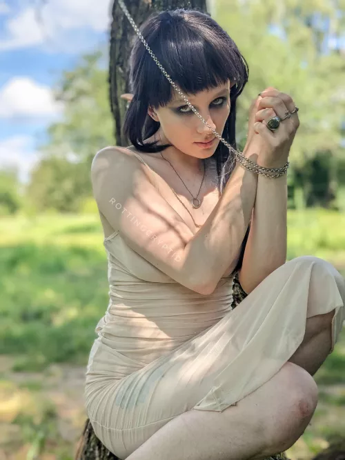 An elven creature chained to the tree