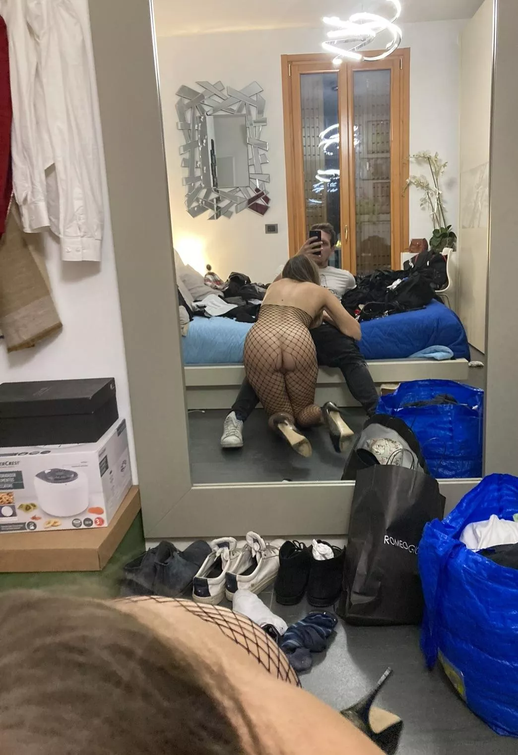 Italian couple in a friends messy bedroom