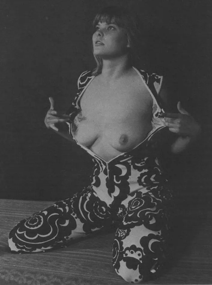 Unknown model unzips her patterned jumpsuit to expose her breasts [1970s]
