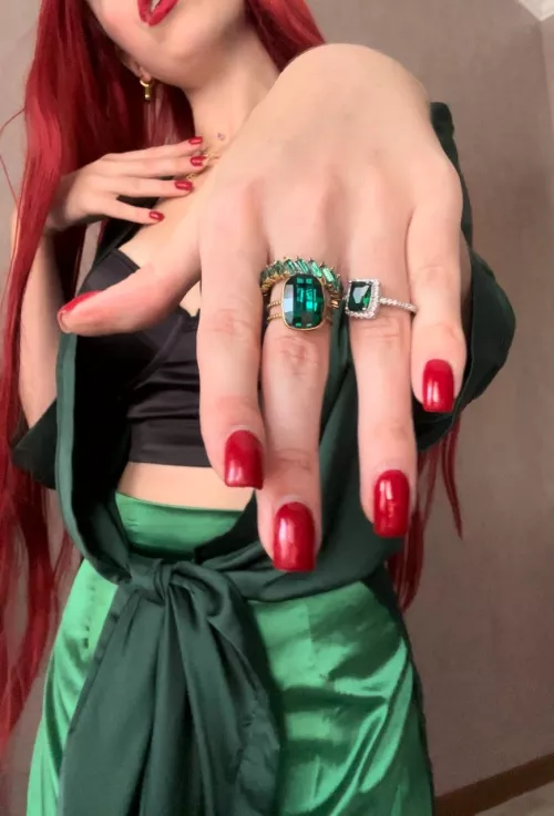 Red manicure and green precious stones go well