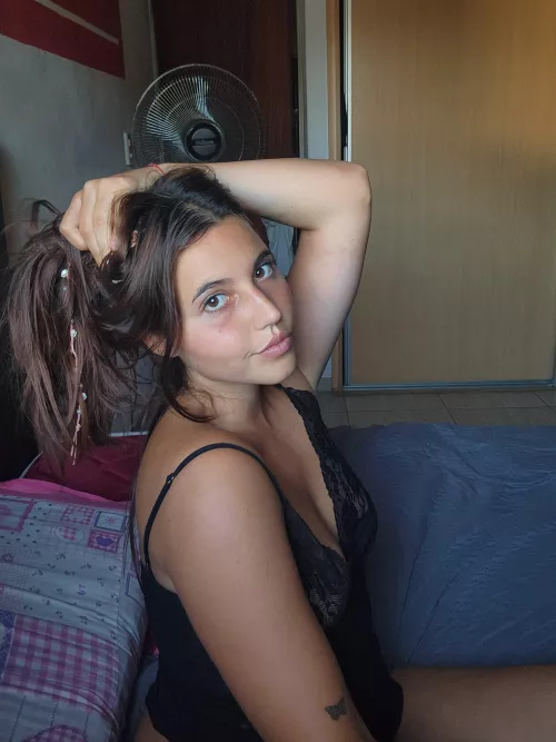 A dark haired beauty waiting on this bed for you