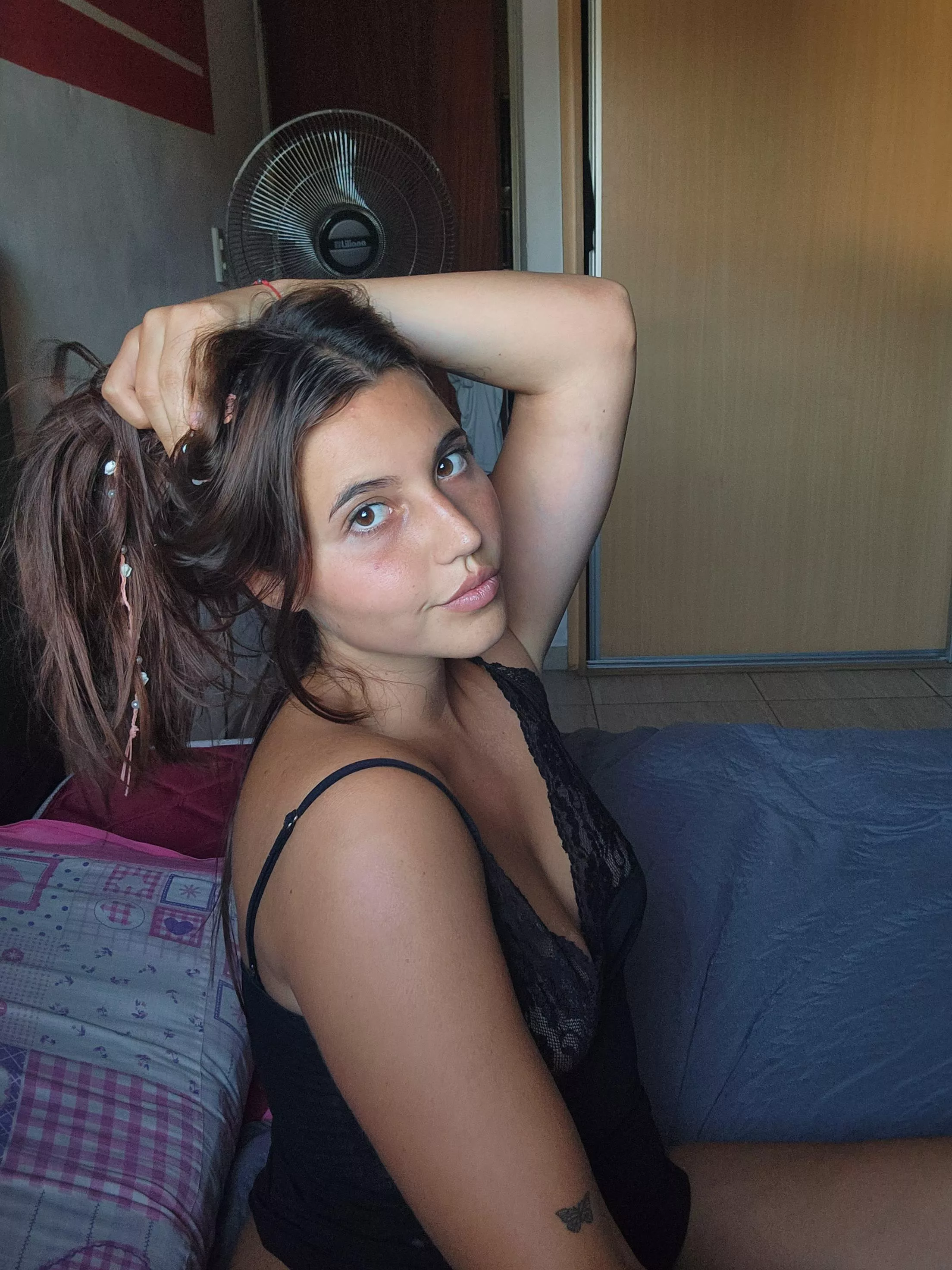 A dark haired beauty waiting on this bed for you