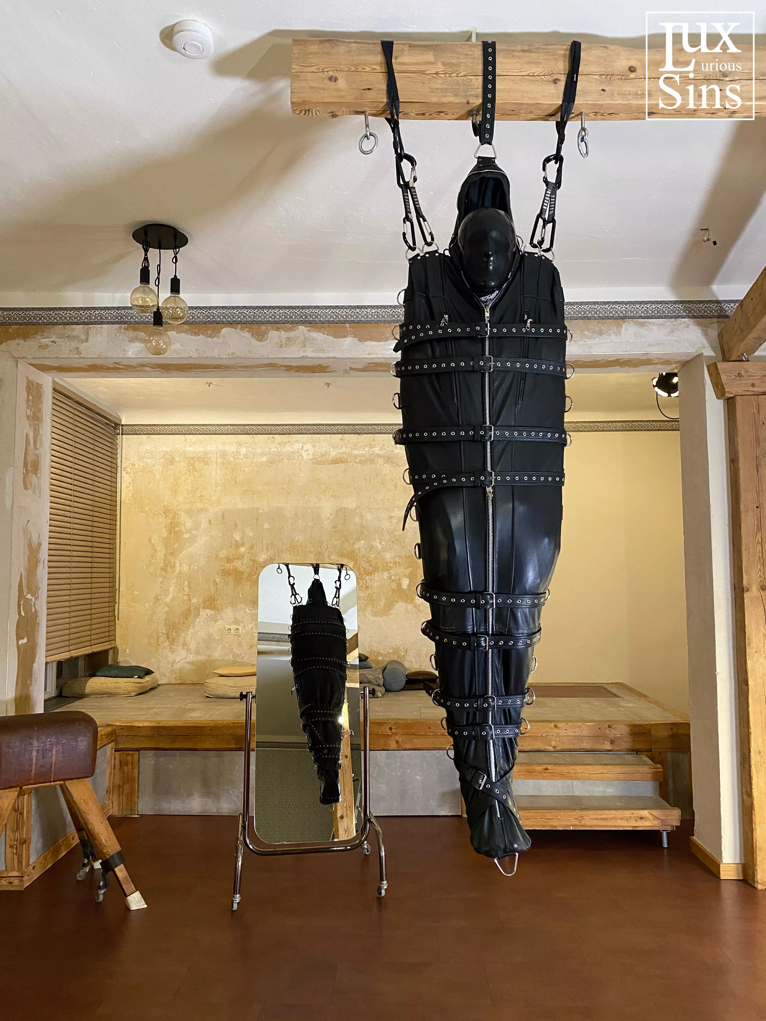 Suspended from the ceiling in a leather sleepsack