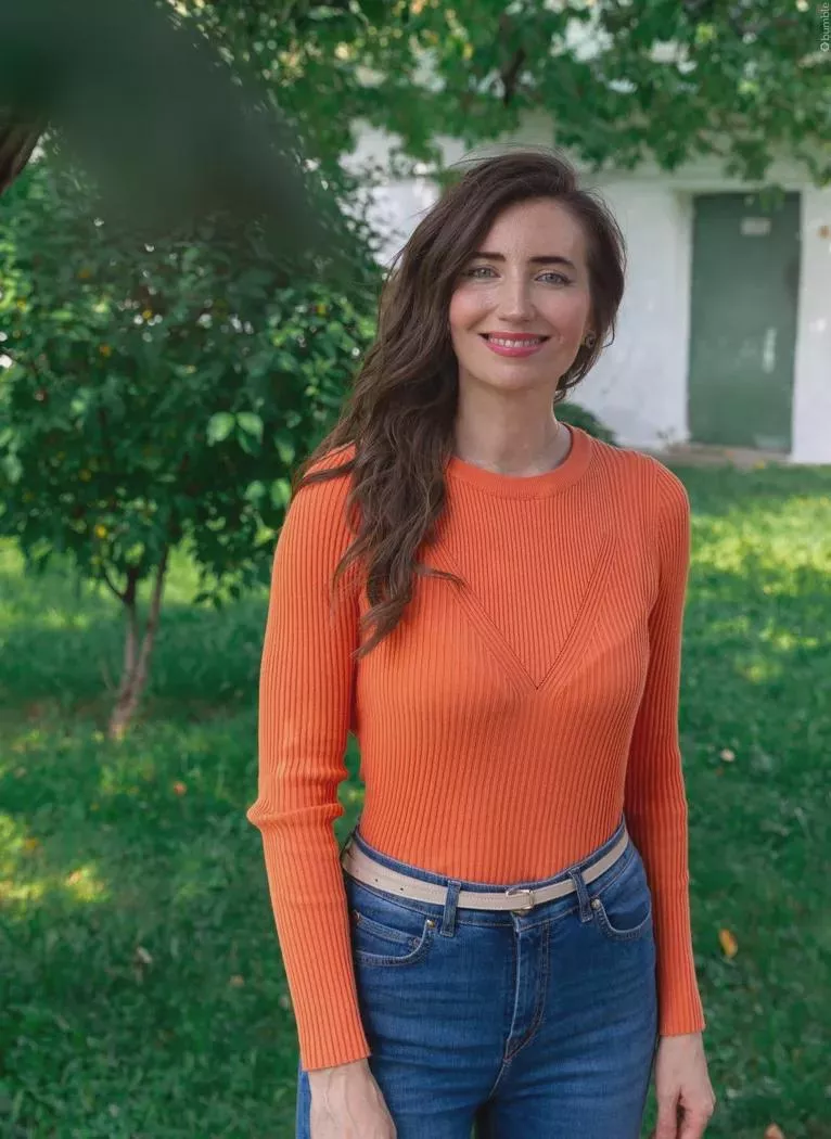 Orange top tight enough to show her bra