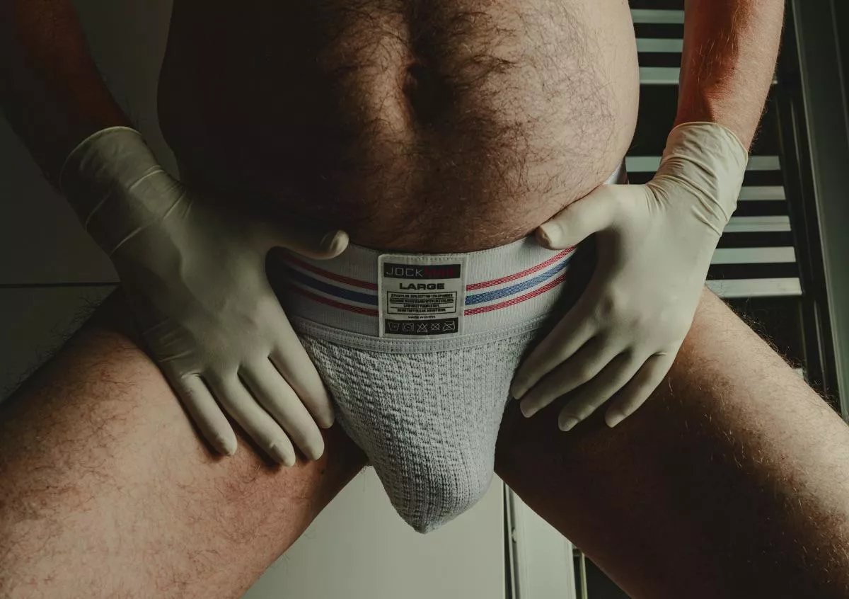 Wearing white gloves and a white jock