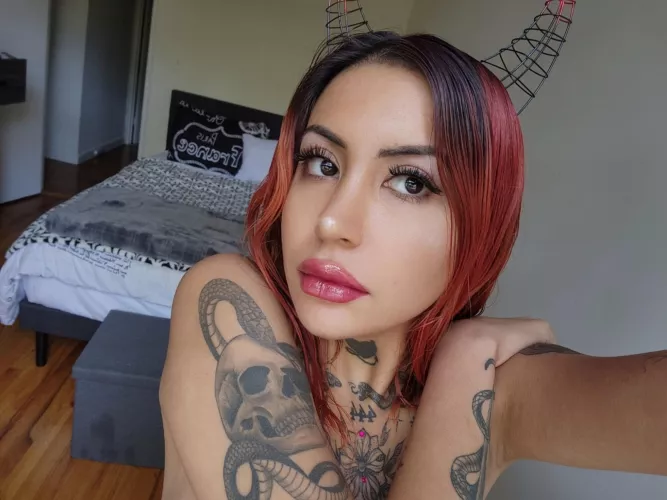 This tattooed redhead is willing to fulfill your dark fantasies