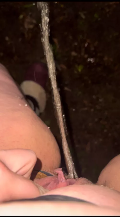 Pissing outside by bush