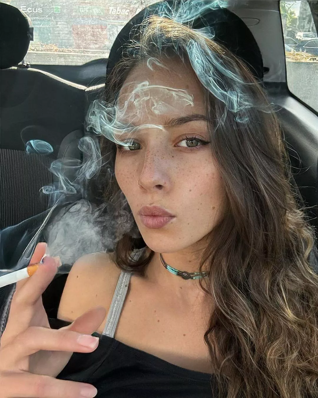 Filling her car with cigarette smoke