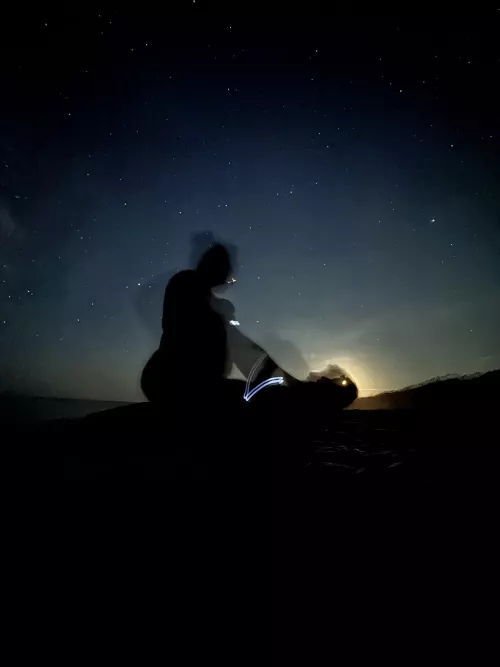 Playing on the beach at midnight, silhouetted against the moon