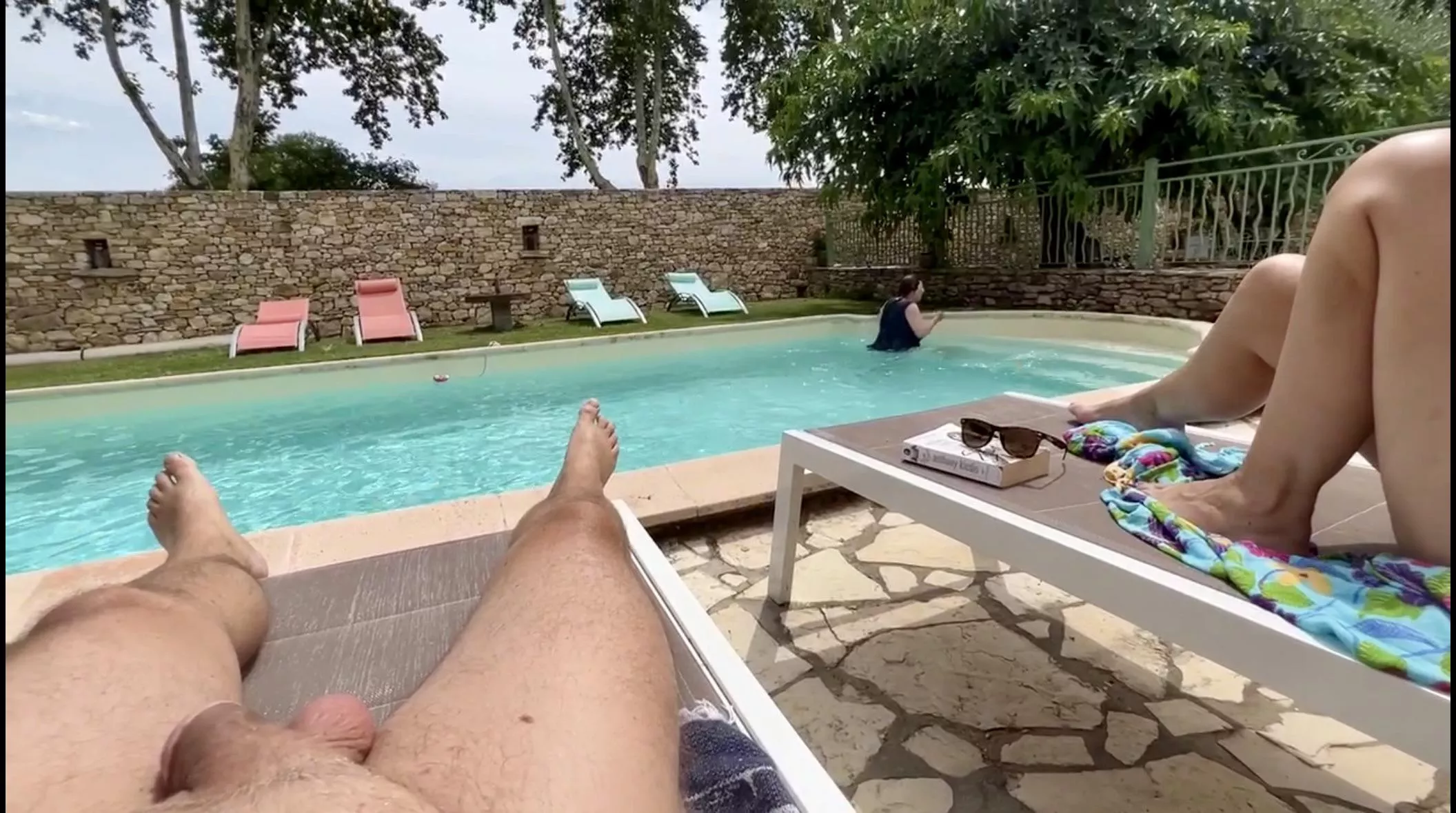 Hubby naked by our Airbnb pool while our clothed host has a swim.