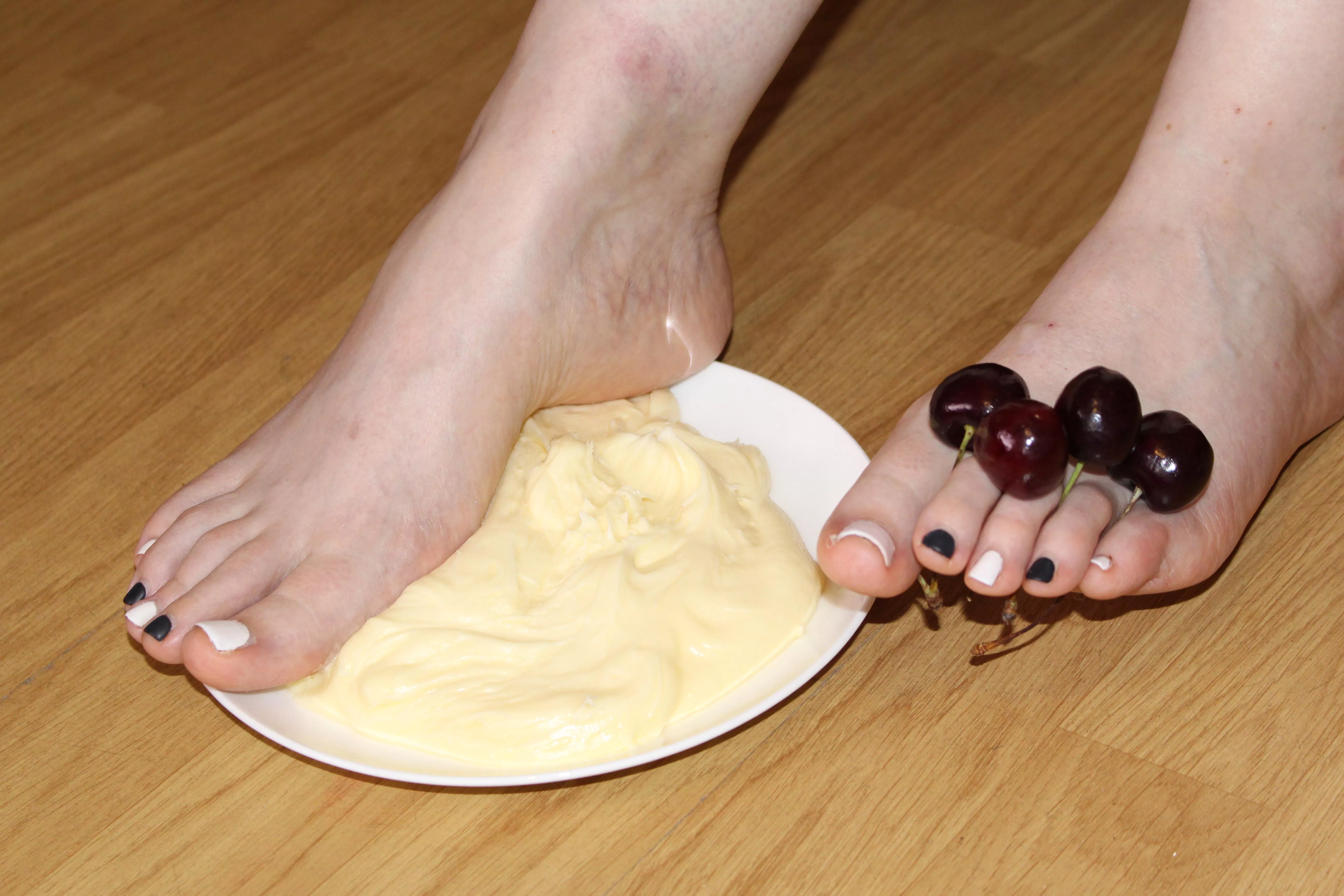 Feet going into vanilla pie, with cherries between my toes