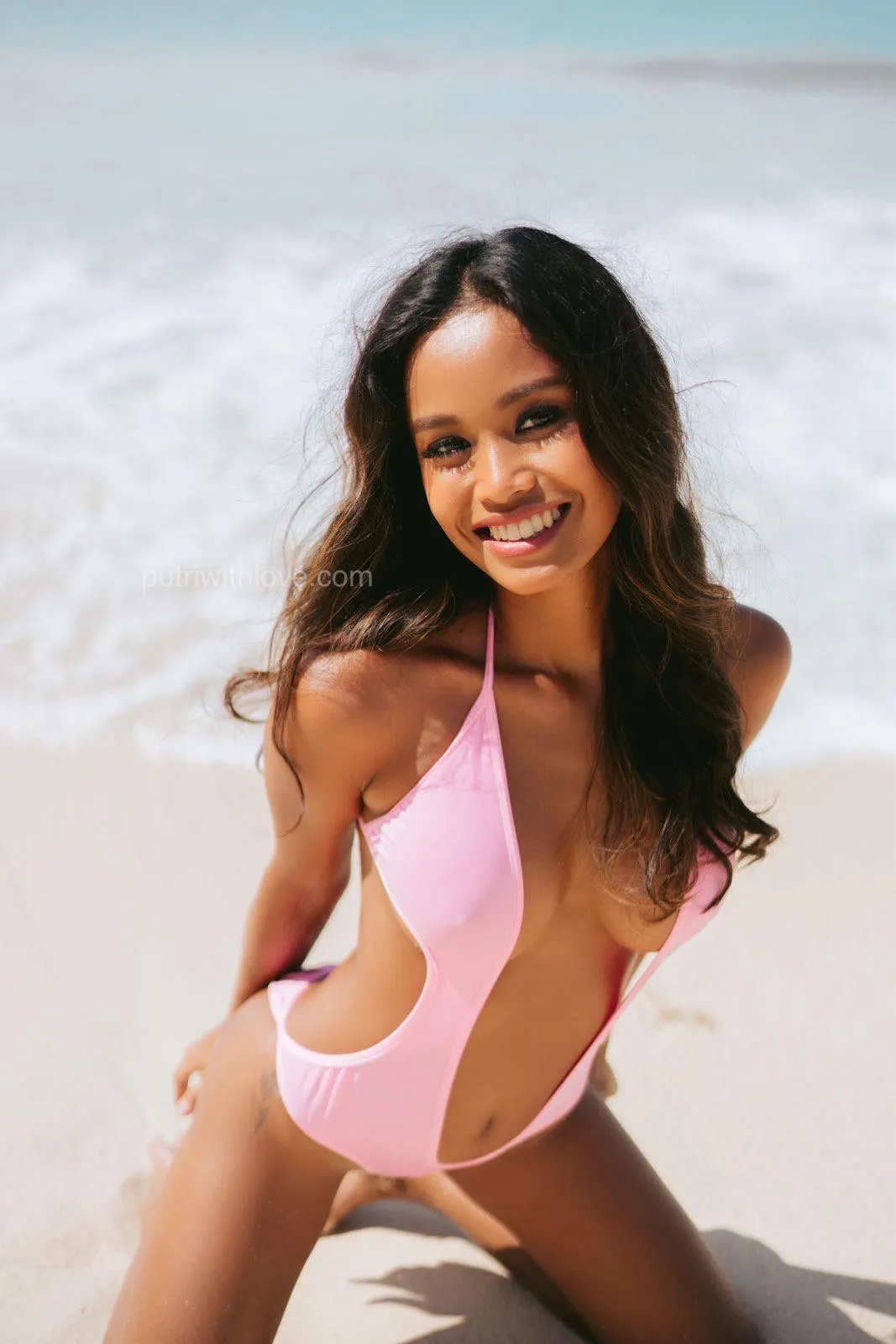 Pink swimsuit, golden tan, and endless beach vibes. 