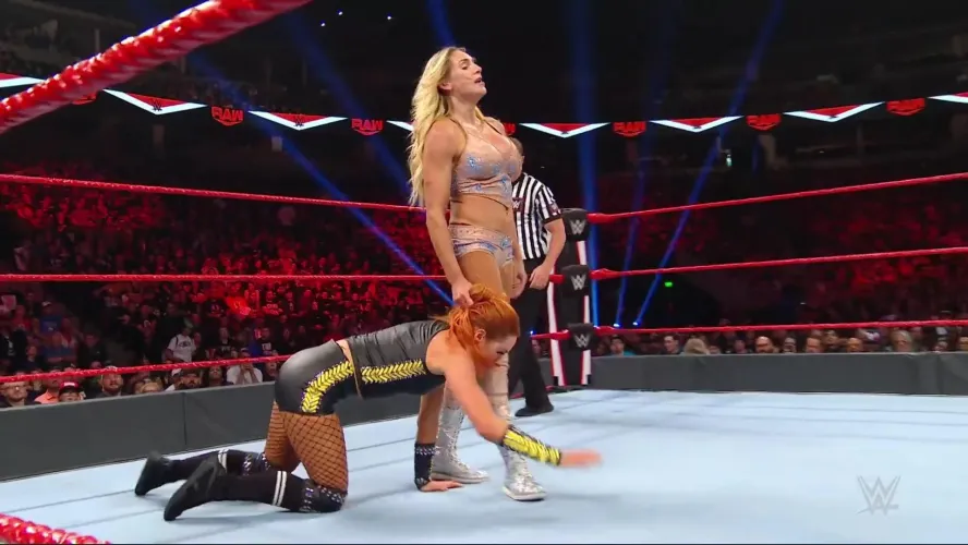 Charlotte Flair walking Becky Lynch like a dog