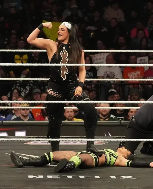 Raquel Rodriguez flexing over an unconscious Roxanne Perez