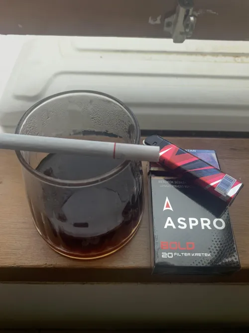 A cup of manual brew coffee and a kretek filtered cig