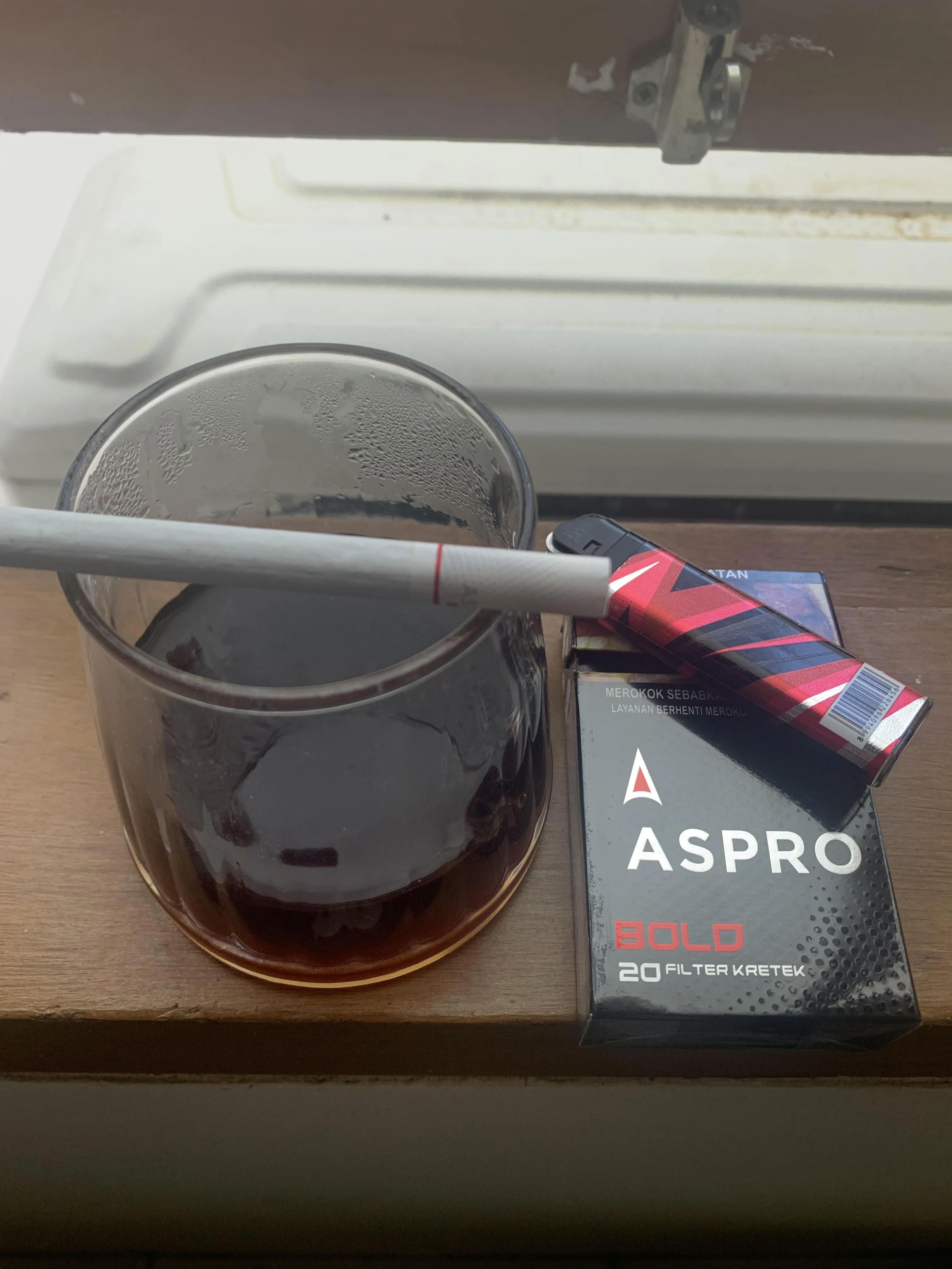 A cup of manual brew coffee and a kretek filtered cig