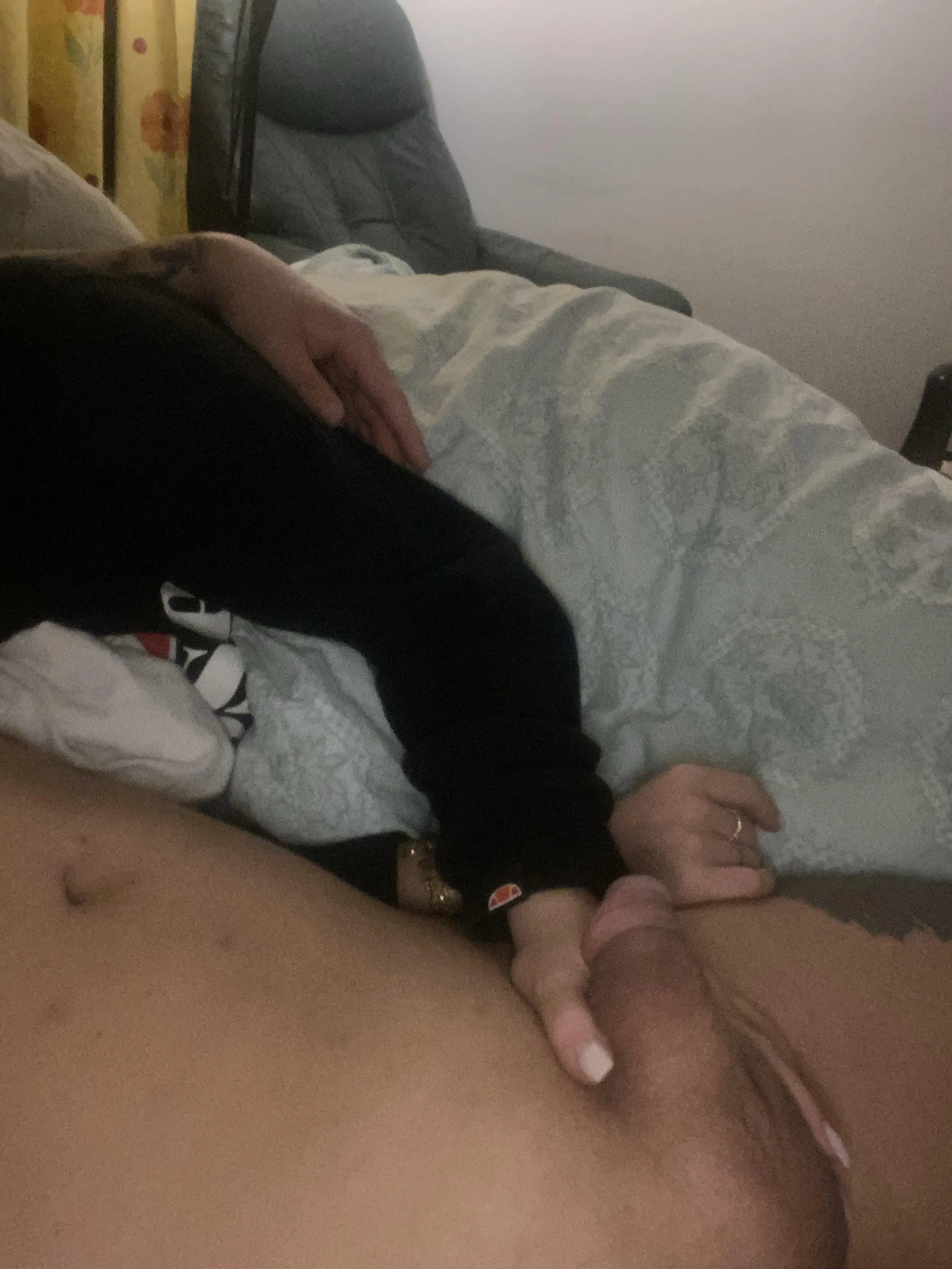 Girl in my hoodie and sweatpants holds my penis while I lay naked besides her.