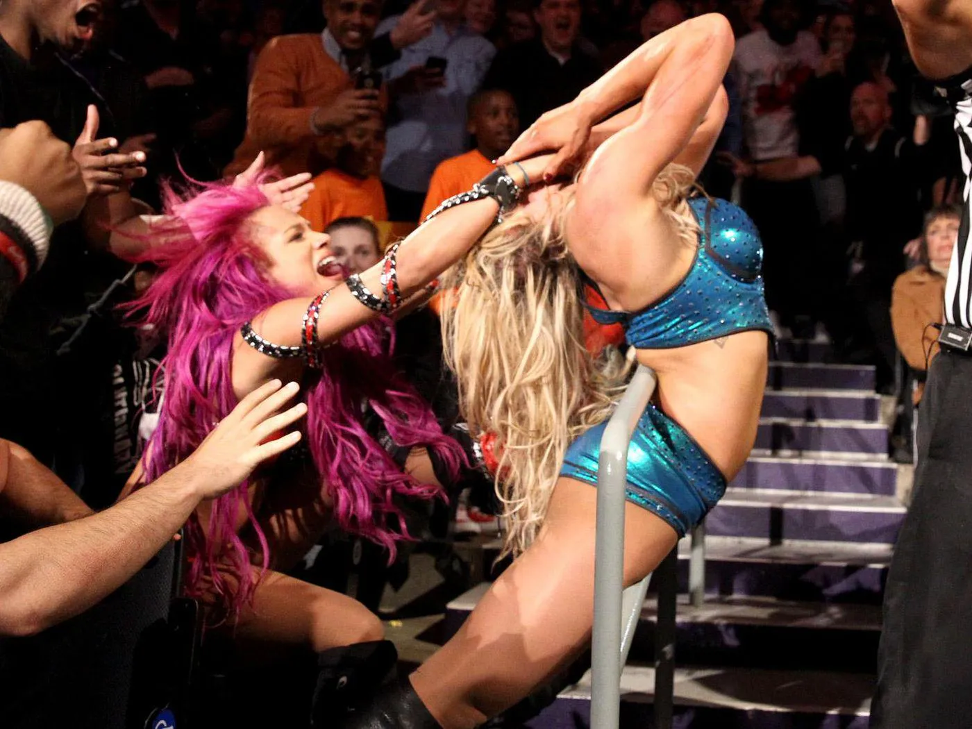 Sasha Banks wraps Charlotte Flair in a hand rail