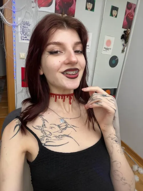 red lips, sharp wings, and a little bit of mischief hiding behind these braces