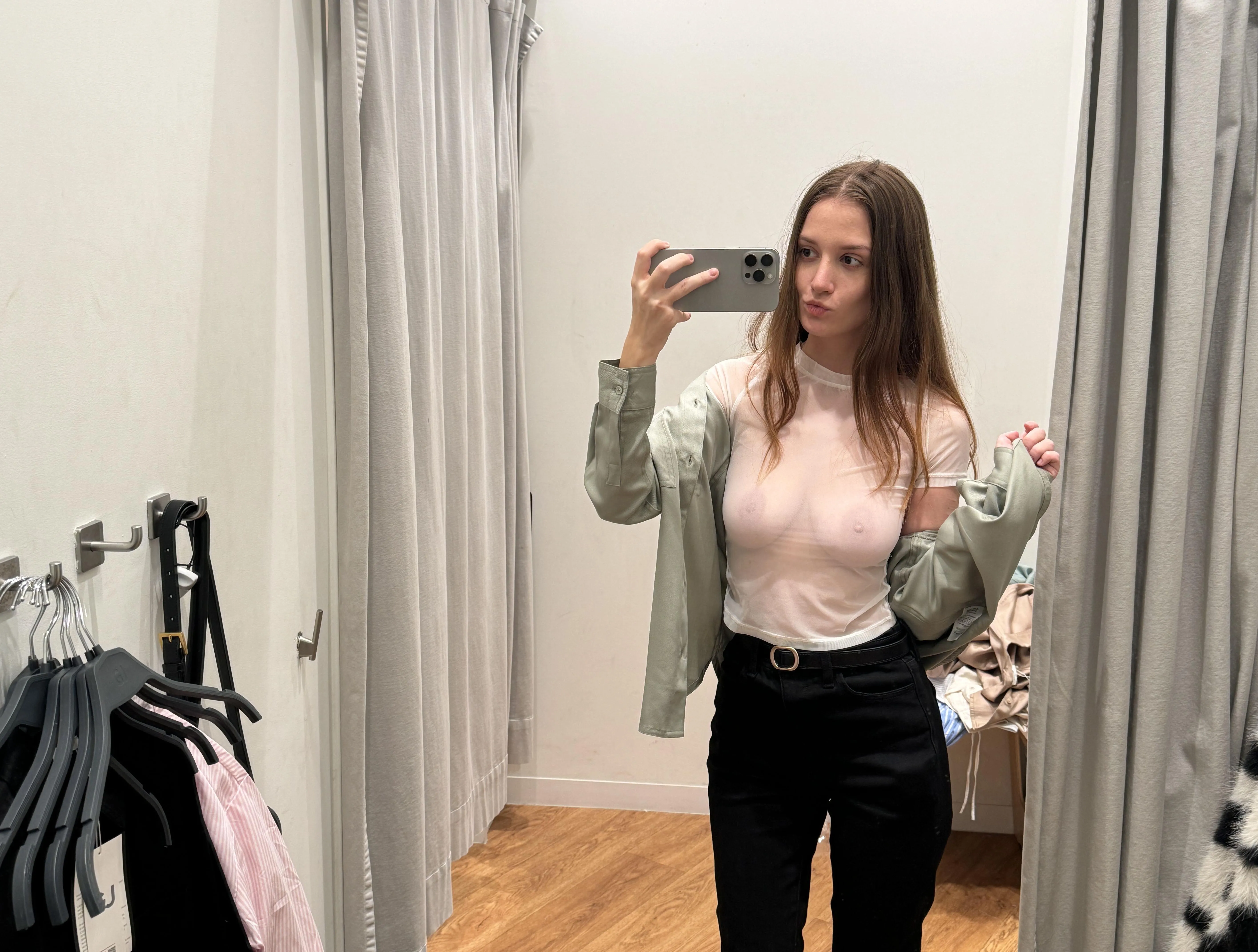 In the changing room, my breasts peek through the sheer fabric, tempting and teasing