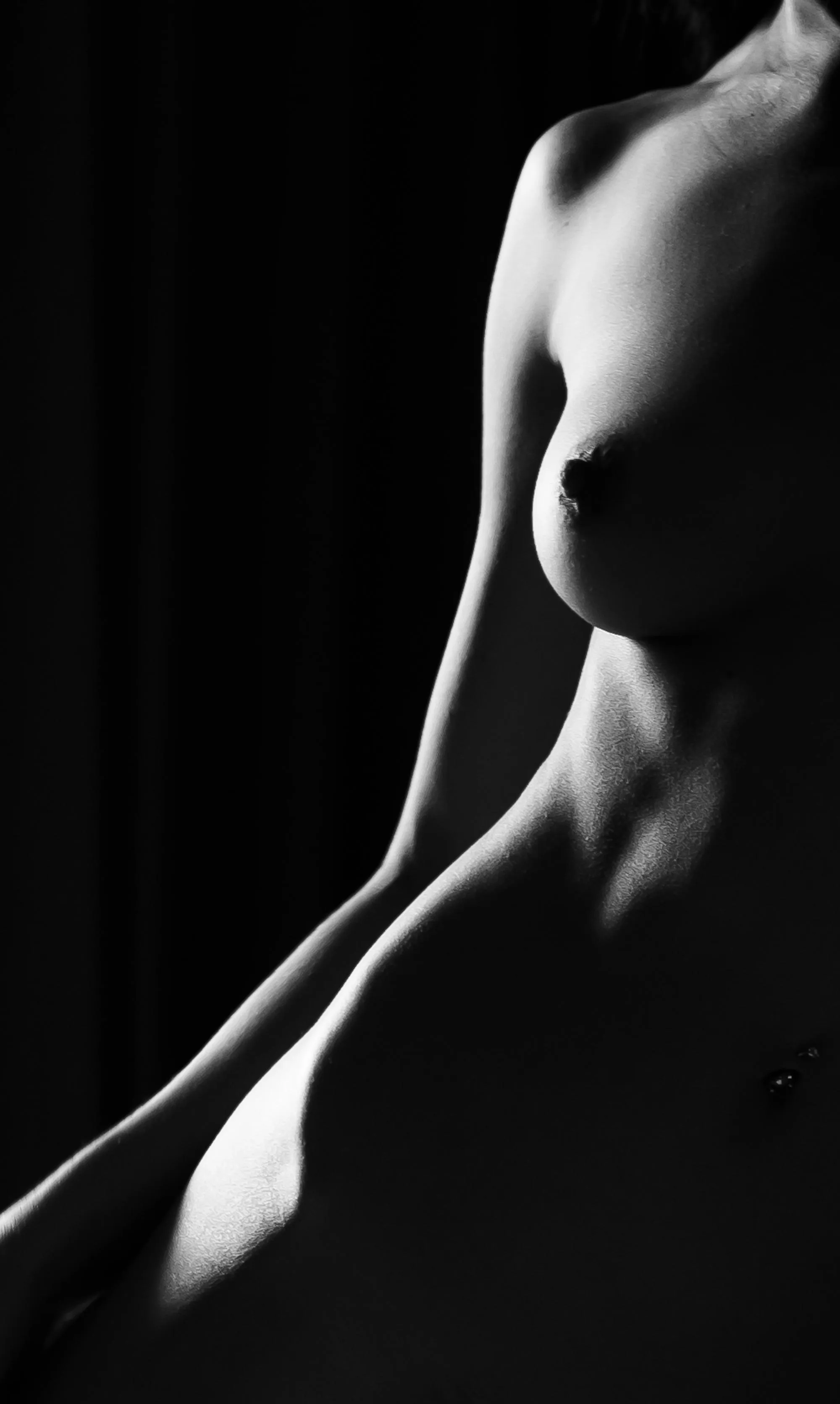 Bodyscape from a dark hotel room with the curtains drawn except for a crack