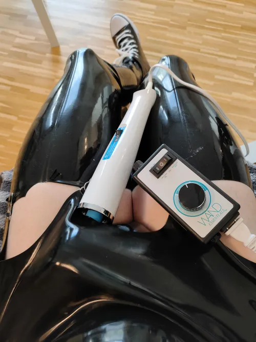 Dressed in latex and playing with a wand vibrator :3